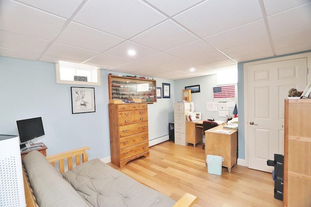 bedroom featuring light wood finished floors and a paneled ceiling