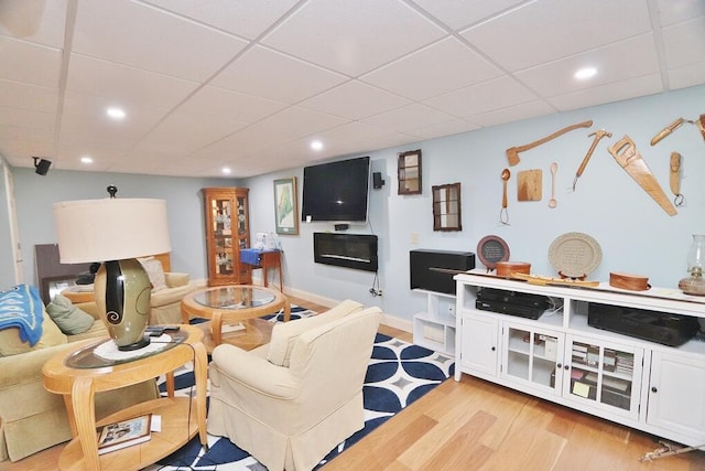 living area featuring light wood-style floors, recessed lighting, and a paneled ceiling
