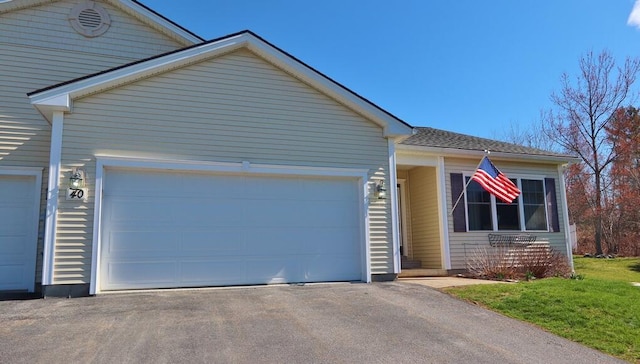 ranch-style house featuring an attached garage, driveway, and a front yard