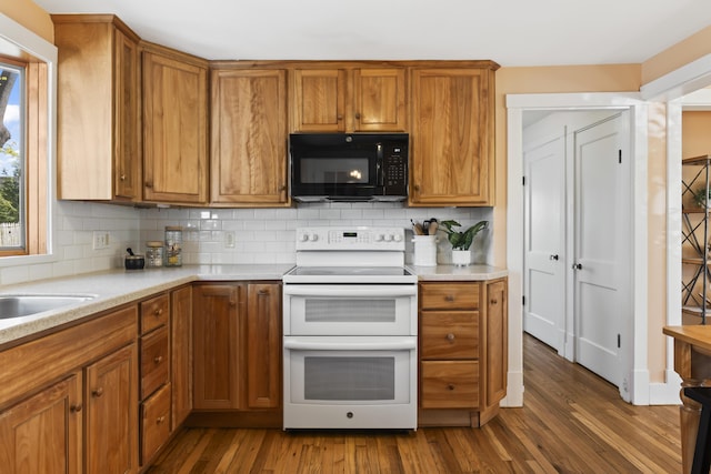 17 US Route 1, Falmouth, ME 04105 - kitchen with black microwave, double oven range, backsplash, dark wood-style floors, and brown cabinetry