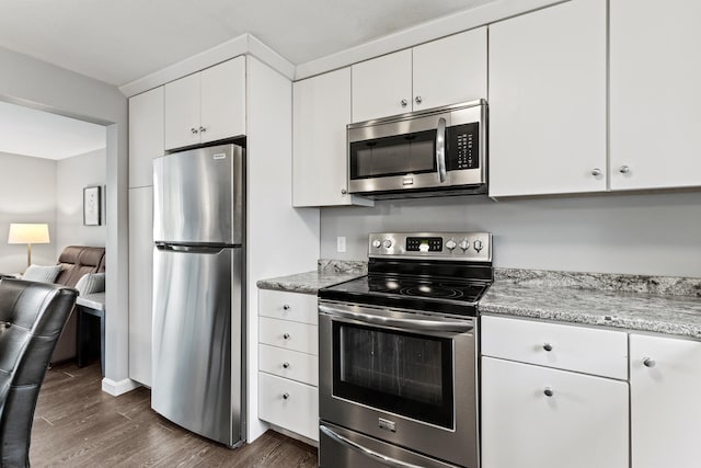 21 Valley St Unit 1, South Portland, ME 04106 - kitchen featuring stainless steel appliances, dark wood-type flooring, white cabinetry, light stone counters, and open floor plan