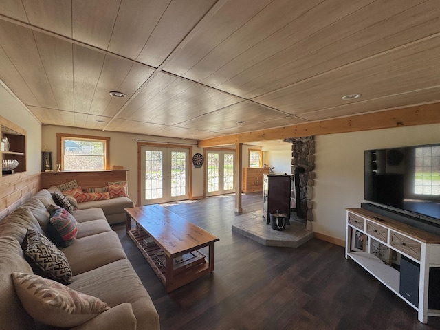 living area featuring french doors, wooden ceiling, a wood stove, and wood finished floors