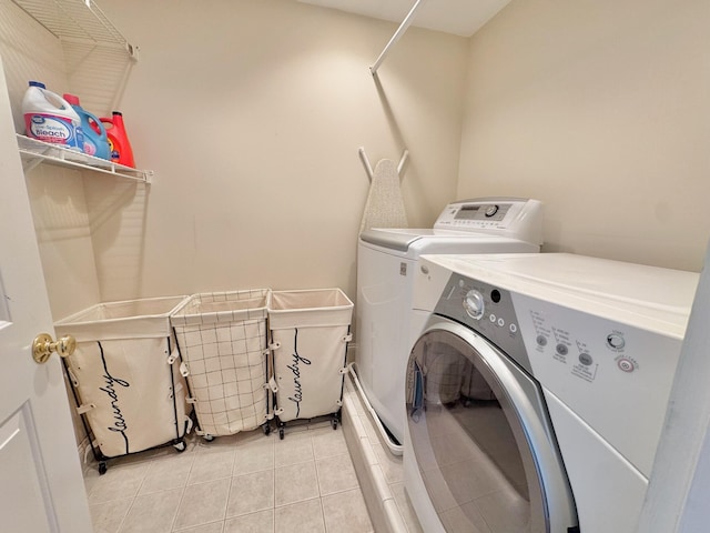 laundry area featuring light tile patterned floors, laundry area, and washer and clothes dryer