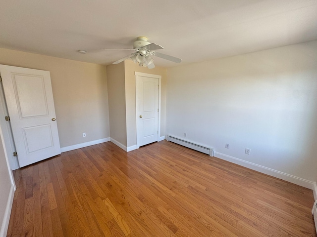 unfurnished bedroom with ceiling fan, baseboards, wood finished floors, a baseboard radiator, and a baseboard heating unit