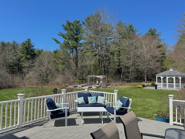 deck with an outdoor living space, a view of trees, a gazebo, and a yard