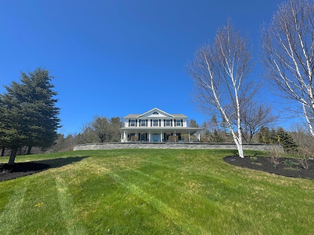 view of front of property featuring covered porch and a front lawn