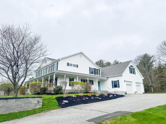 farmhouse with a garage, covered porch, and aphalt driveway