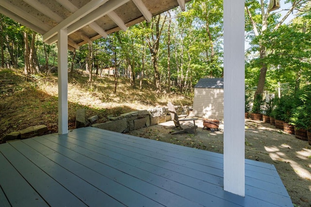 deck featuring a storage shed, an outbuilding, and an outdoor fire pit