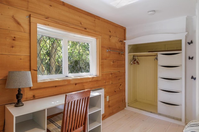 unfurnished office featuring wood walls and light wood-type flooring