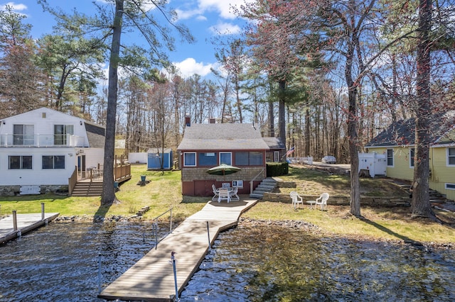 view of dock featuring a lawn and a water view