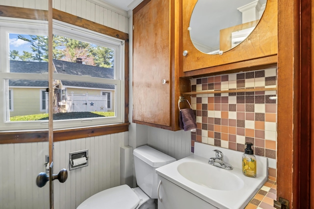 half bath featuring toilet, a sink, and tasteful backsplash