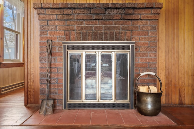 room details featuring a brick fireplace, wood walls, wood finished floors, and visible vents