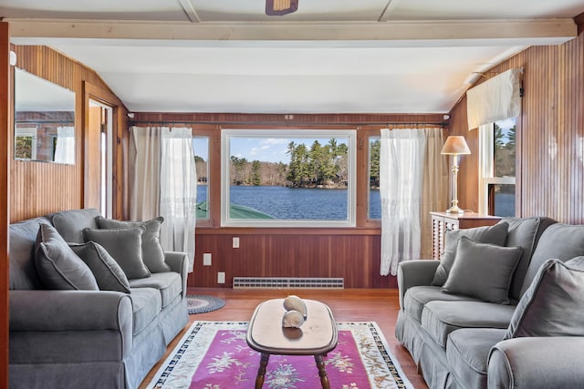 sunroom / solarium featuring plenty of natural light, a baseboard radiator, and a water view