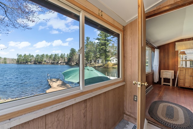 doorway to outside with wood-type flooring, a water view, wooden walls, and vaulted ceiling