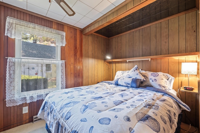 bedroom with carpet floors and wood walls