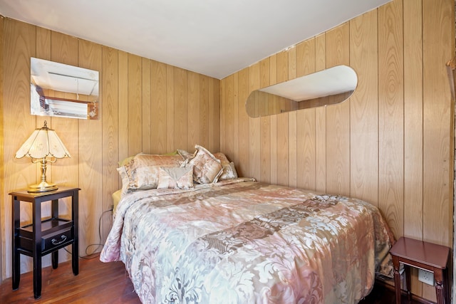 bedroom featuring wood finished floors and wooden walls