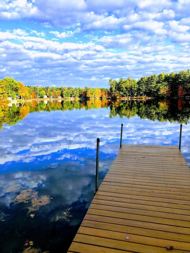 view of dock featuring a water view and a wooded view