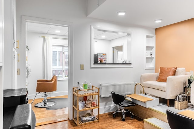 interior space featuring radiator heating unit, baseboards, recessed lighting, and wood finished floors