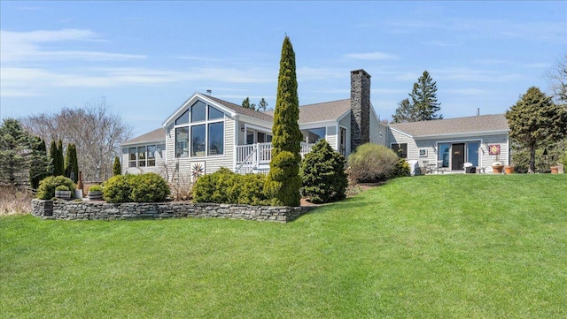 back of property with a lawn and a chimney