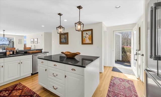 kitchen featuring dark countertops, stainless steel appliances, light wood finished floors, and a wealth of natural light