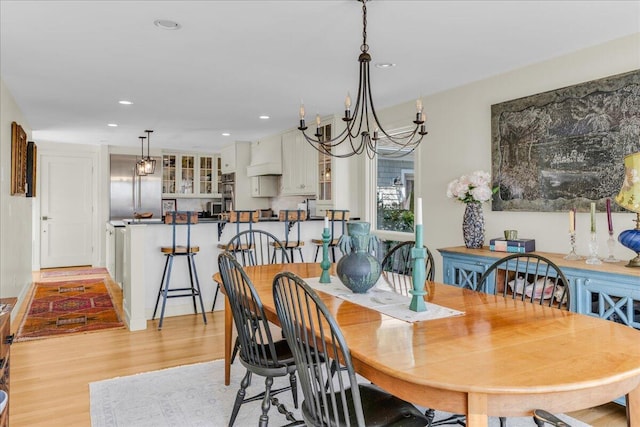 dining space featuring light wood-style floors, recessed lighting, and a chandelier