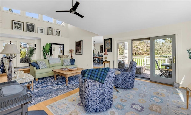 living area with ceiling fan, a high ceiling, wood finished floors, and a wealth of natural light