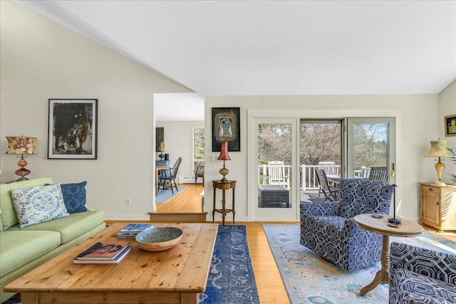 living area with baseboards, wood finished floors, and lofted ceiling