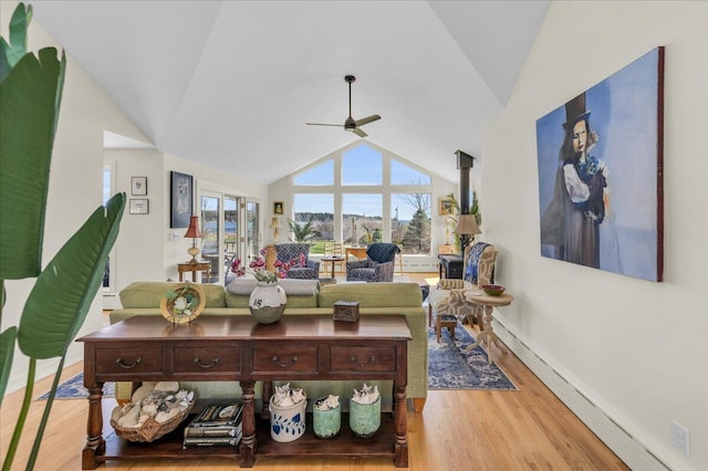 living area with baseboards, ceiling fan, vaulted ceiling, and wood finished floors