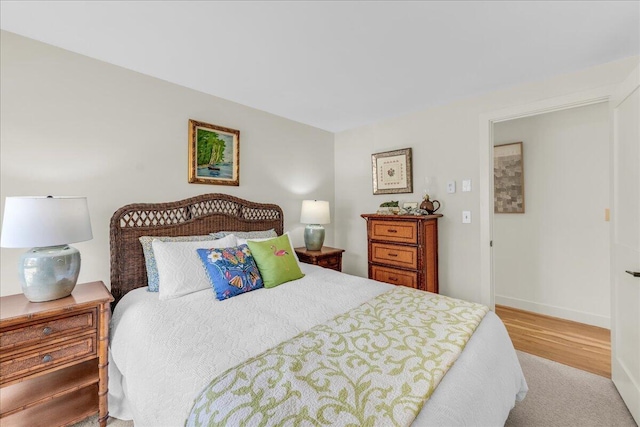 bedroom featuring baseboards and wood finished floors