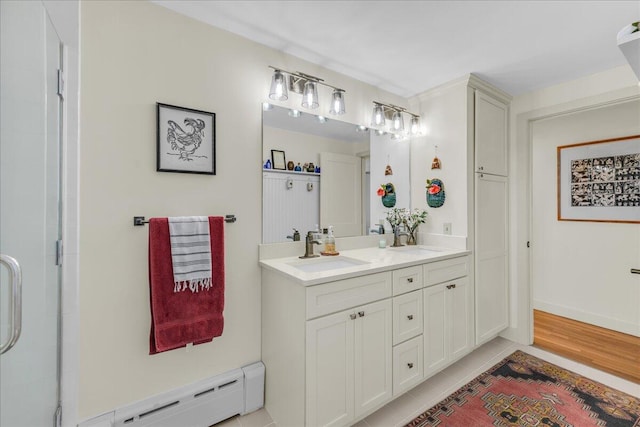 bathroom with double vanity, baseboard heating, an enclosed shower, tile patterned floors, and a sink