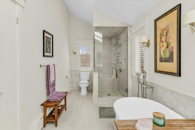 full bathroom featuring toilet, tile walls, lofted ceiling, a soaking tub, and a stall shower