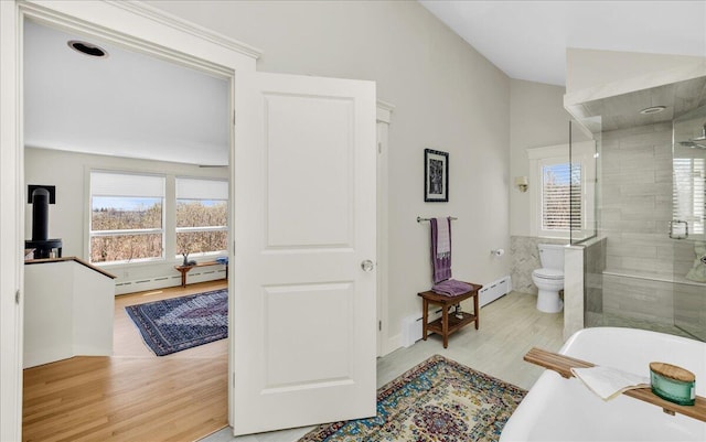 bathroom with a stall shower, a freestanding bath, lofted ceiling, and a healthy amount of sunlight