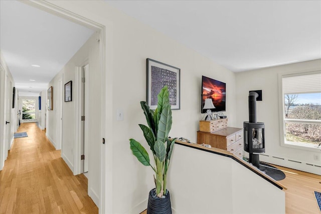 corridor featuring baseboards, recessed lighting, light wood-style flooring, and a baseboard heating unit
