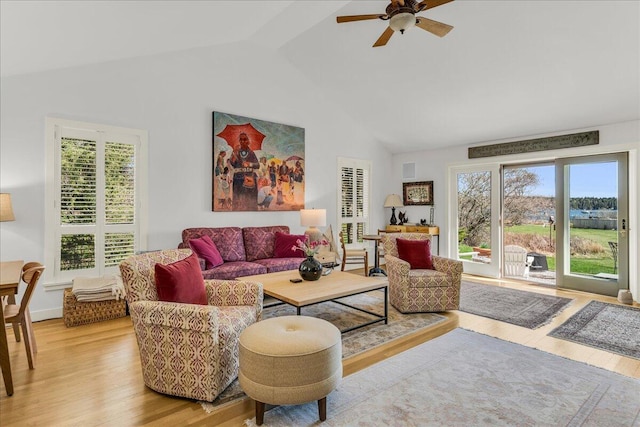 living room with light wood finished floors, ceiling fan, and high vaulted ceiling