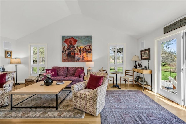 living room featuring plenty of natural light, wood finished floors, and lofted ceiling