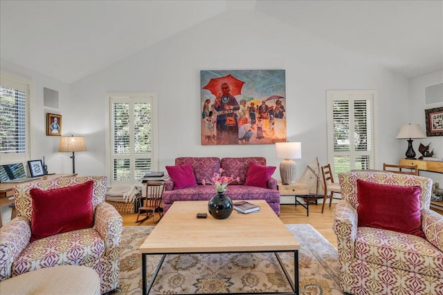 living room with wood finished floors and high vaulted ceiling
