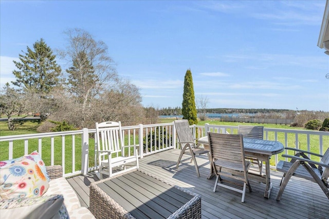 wooden deck with outdoor dining area and a yard