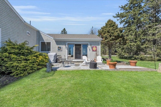 back of house featuring a lawn, a patio, and a shingled roof