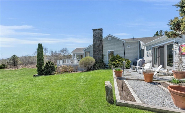view of yard featuring a wooden deck and a patio