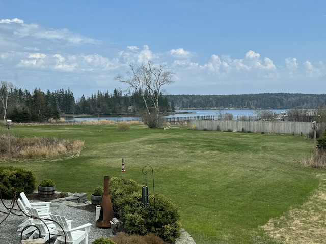 view of yard featuring a water view, a view of trees, and fence