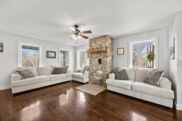 living room with a ceiling fan, dark wood-style flooring, and a healthy amount of sunlight