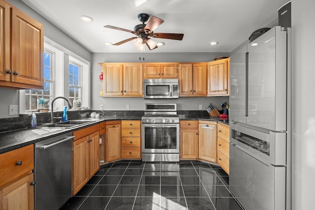 kitchen with ceiling fan, dark countertops, appliances with stainless steel finishes, and a sink