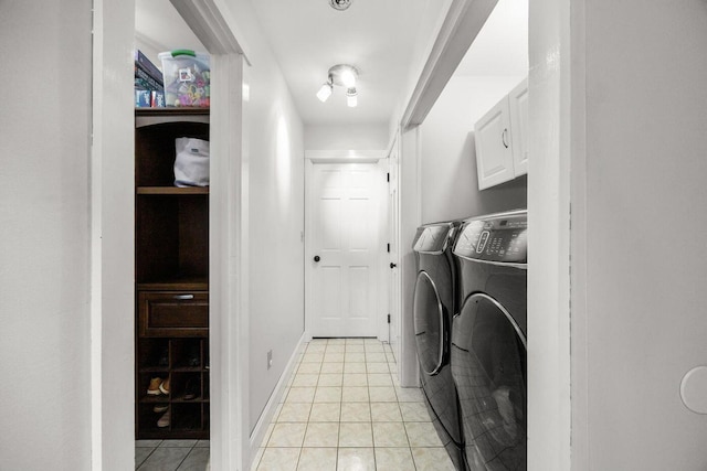 laundry room with cabinet space, light tile patterned floors, and separate washer and dryer