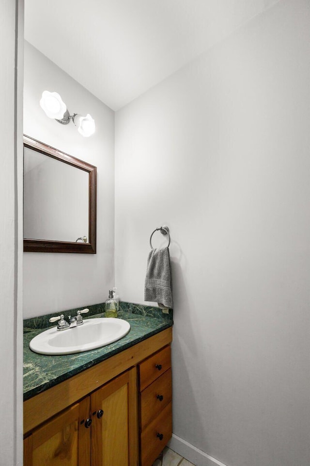 bathroom with vanity, baseboards, and tile patterned flooring