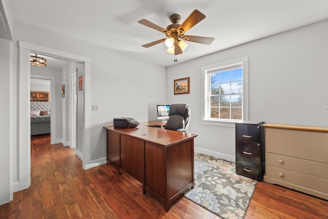 office featuring baseboards, ceiling fan with notable chandelier, and wood finished floors