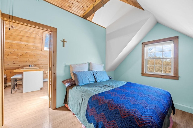 bedroom featuring multiple windows, vaulted ceiling, wood finished floors, and baseboards