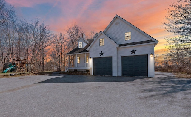 property exterior at dusk with aphalt driveway, a garage, and an attached garage