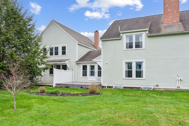 10 Ephraim Tyler Way Unit 10, Kennebunk, ME 04043 - rear view of property with a chimney, a lawn, a wooden deck, and a shingled roof