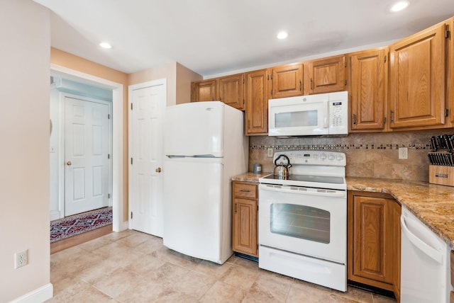 10 Ephraim Tyler Way Unit 10, Kennebunk, ME 04043 - kitchen with white appliances, backsplash, recessed lighting, light stone countertops, and brown cabinetry
