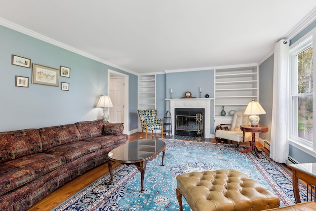 10 Ephraim Tyler Way Unit 10, Kennebunk, ME 04043 - living room with wood finished floors, built in features, a fireplace with flush hearth, crown molding, and baseboards